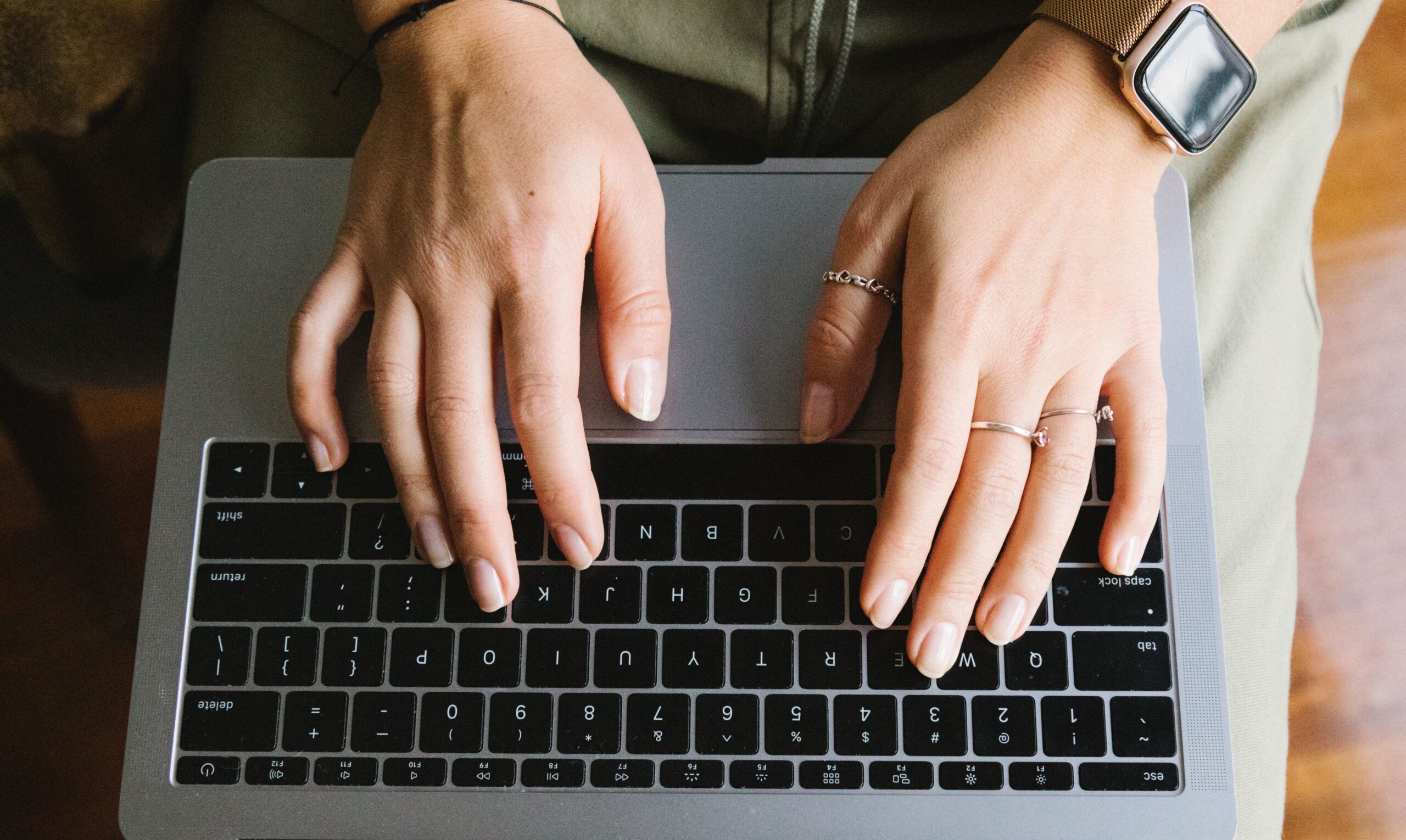 Χέρια πληκτρολογούν σε laptop με γραφήματα απόδοσης social media